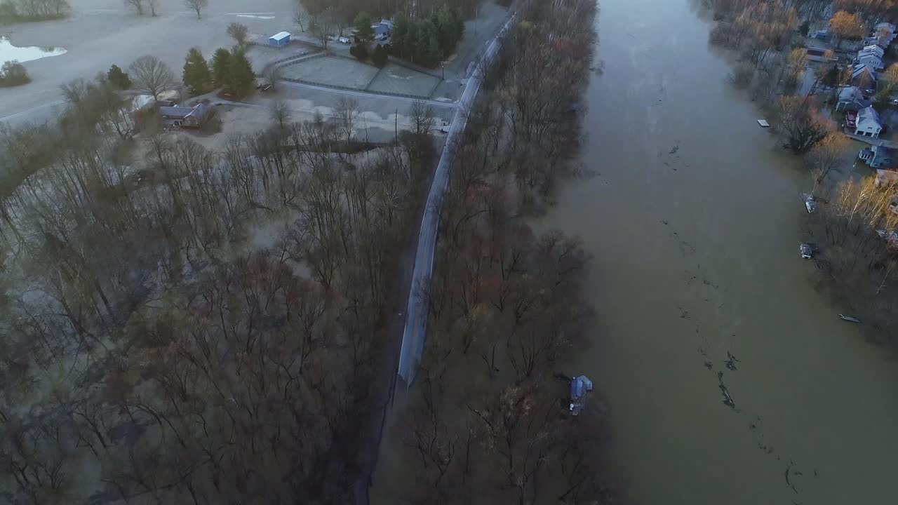 Aerial of neighborhood in Kentucky USA after river flooded and submerged withered trees in winter