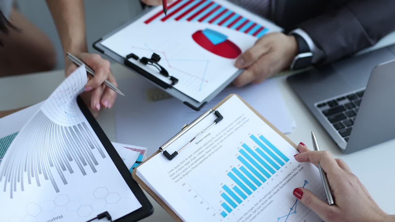 personas de negocios tormenta de ideas papeles informes financieros o gráficos de ventas en la reunión