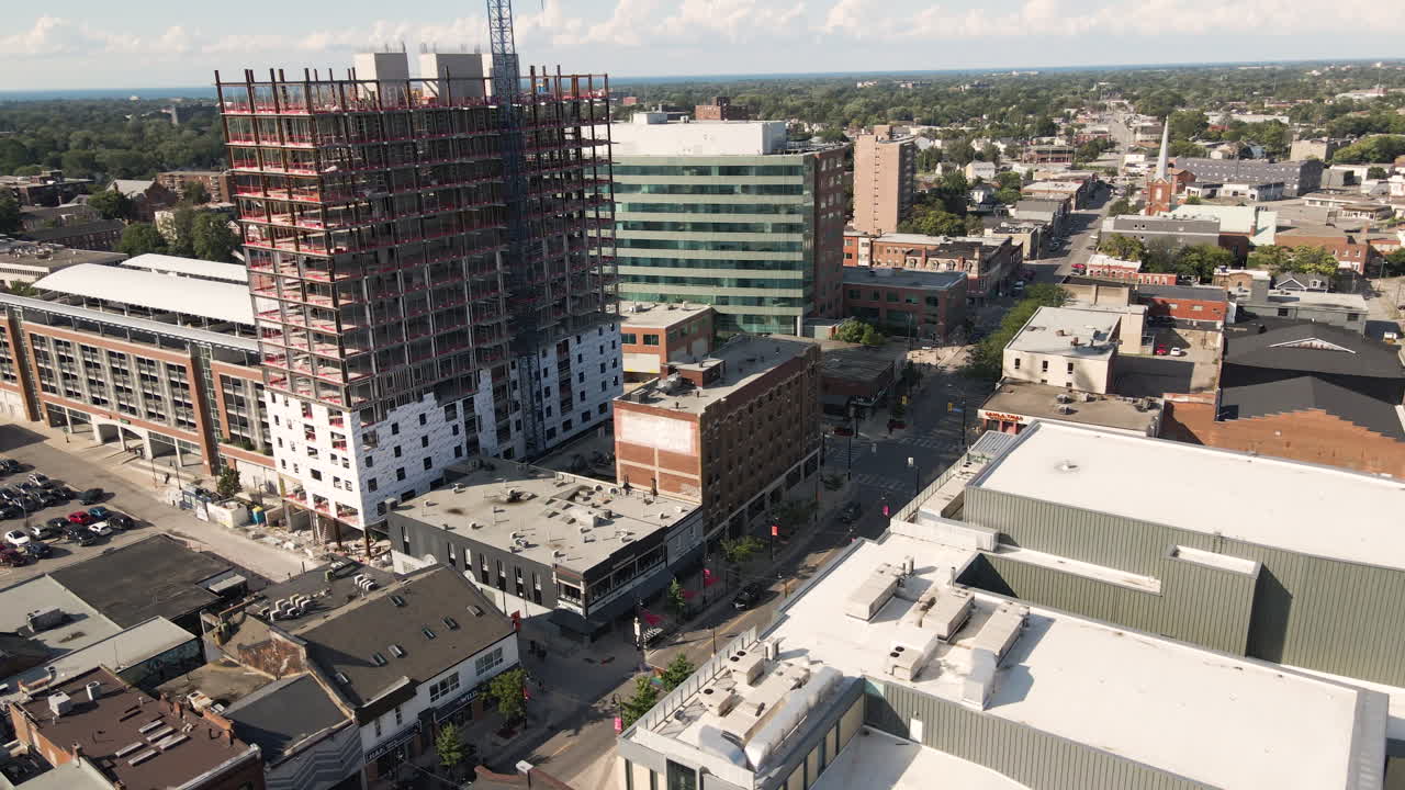drones en órbita por encima de la calle linda llena de tiendas de diversión al lado de nuevos edificios de oficinas de apartamentos y grúas