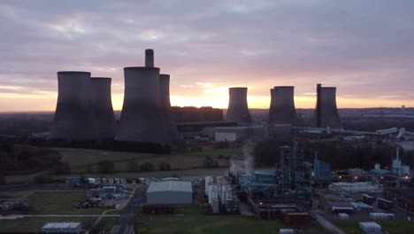los violinistas transportan una central eléctrica alimentada con carbón en desuso al amanecer, vista aérea detrás de un punto de referencia, toma de empuje