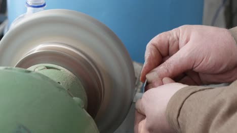 el trabajo en el molinillo de pedestal, la producción de artículos, el acabado de las piezas metálicas en la fábrica
