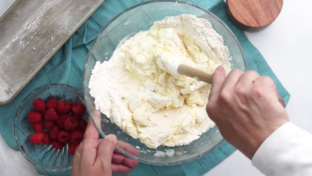 Making a dessert called Red Raspberry Tea Cake made with fresh berries and vanilla buttercream frosting. Great for Tea Parties. Adding sour cream into the mixing bowl and combining the ingredients