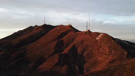 Inclinación-Aérea-De-Paralaje-De-Las-Montañas-De-El-Paso-Con-Torres-De-Radio-Al-Atardecer