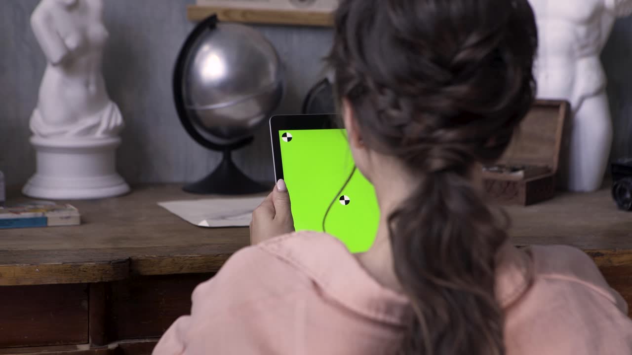 mujer usando una tableta con una pantalla verde