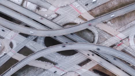 tiempo aéreo lapso atasco de tráfico intersección de carretera, disparo de avión no tripulado de arriba hacia abajo zoom out vista de la intersección de la carretera en la ciudad moderna por la noche. coches lapso de tiempo conduciendo ocupada rotonda de la autopista de unión en movimiento rápido