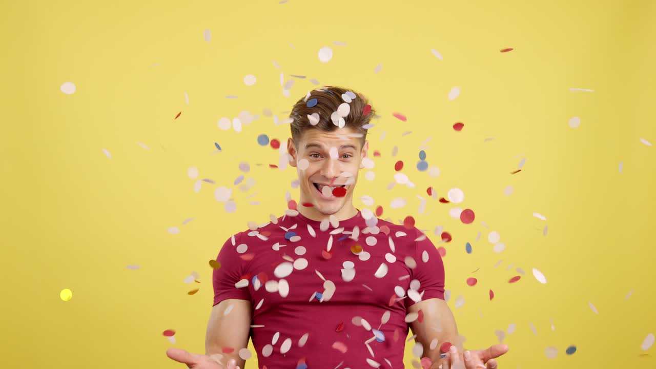 Uomo felice che celebra con i confetti che cadono attorno a lui