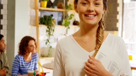 Portrait-of-beautiful-waitress-holding-menu-card-4k