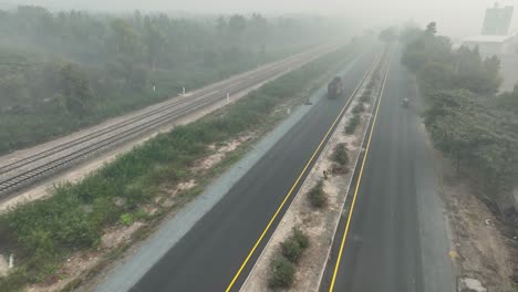 Drone-Vuela-Hacia-Atrás-Sobre-Sahiwal-A-Multan-Road-En-Punjab,-Hay-Mucha-Niebla