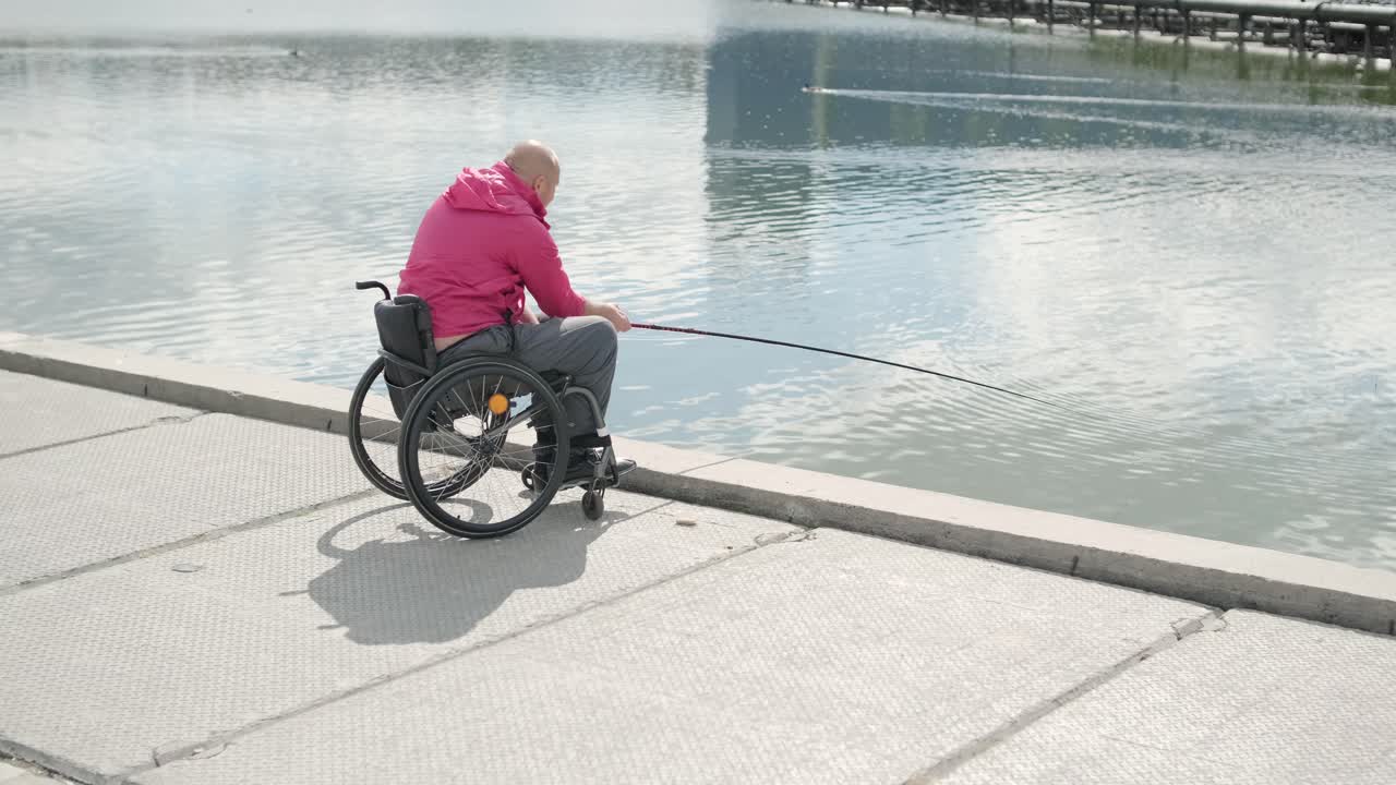 persona con discapacidad física que utiliza silla de ruedas para pescar en el muelle de pesca