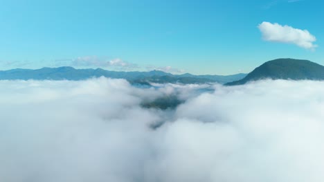 above the clouds impressive aerial timelapse, flying over the sea of mist with mountains in the background, view from the airplane