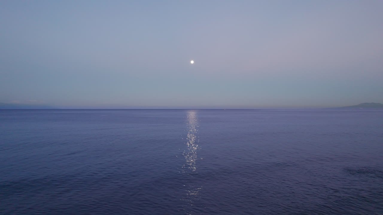 해가 물 위에 달의 반사와 함께, 새벽에 포착