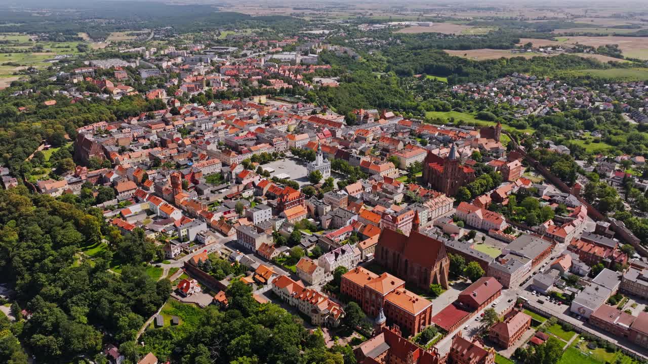Drone orbit reveals Chelmno Poland old town with red rooftops, Gothic churches