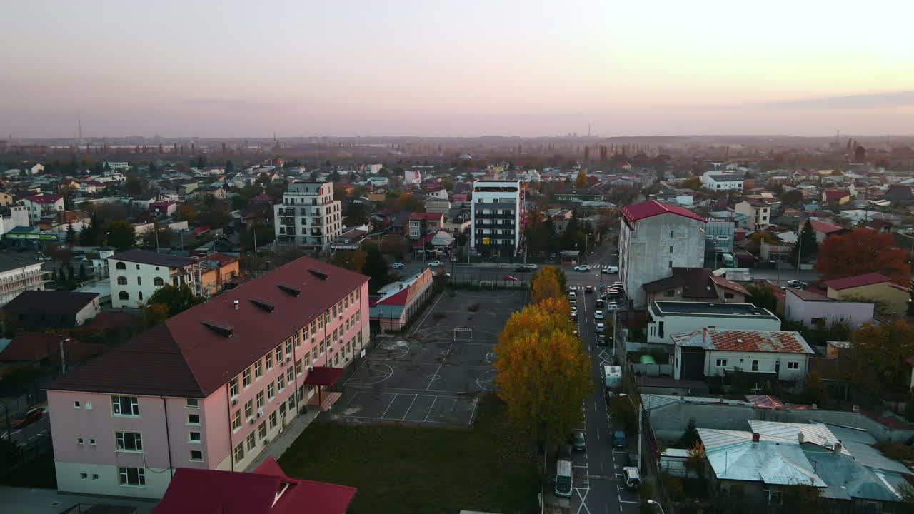 Residential district with low buildings, playground, road with moving cars. View from the drone, panorama view. Bucharest, Romania