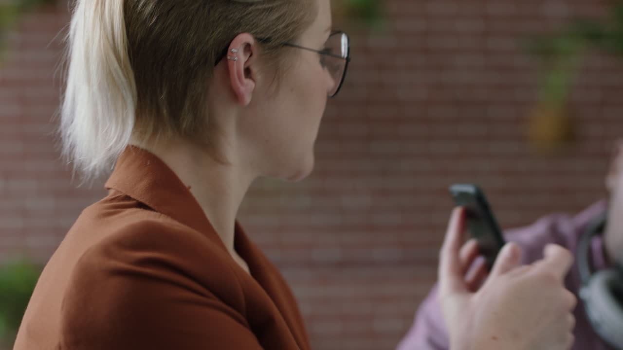 ingenieros diversos desarrollando aplicaciones de software móvil líder de equipo caucásico mujer usando teléfono inteligente compartiendo ideas de diseño lluvia de ideas en la reunión de presentación de la oficina