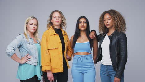 studio shot of young independent multi-cultural female friends looking into camera in slow motion