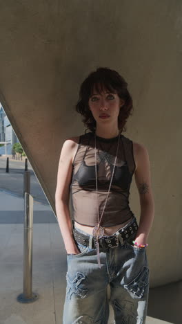 Vertical-Video-Outdoor-Fashion-Portrait-Of-Young-Alternative-Style-Woman-With-Tattoos-And-Piercing-Standing-Outside-Modern-Buildings-At-Canary-Wharf-London-Shot-In-Real-Time