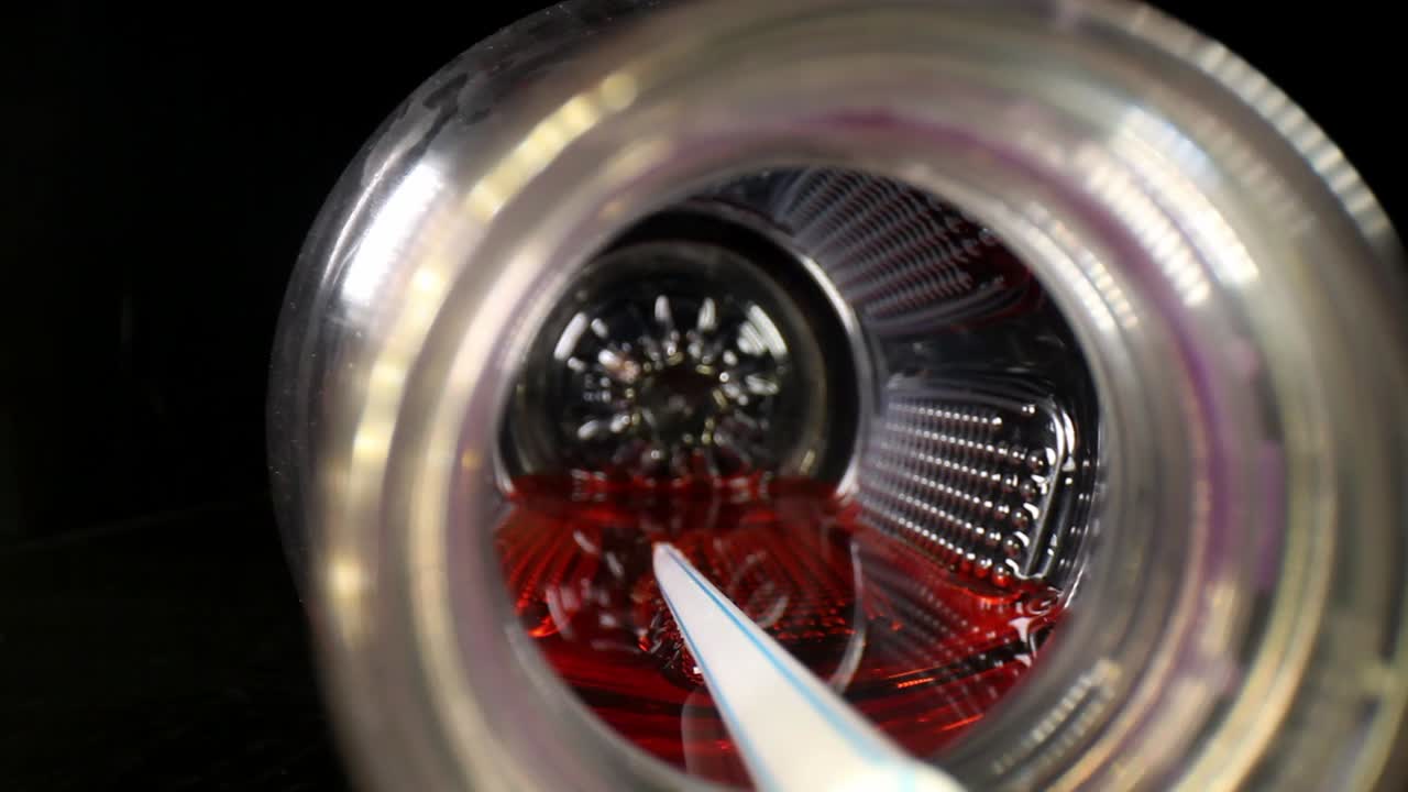 스포츠 음료수 병을 왼쪽 오프셋으로 밀고, 렌즈가 열리면 렌즈가 움직입니다. 그런 다음 중앙에 있고 병에 들어갑니다. 빨간색 액체에 흰색 빨대가 들어 있습니다.