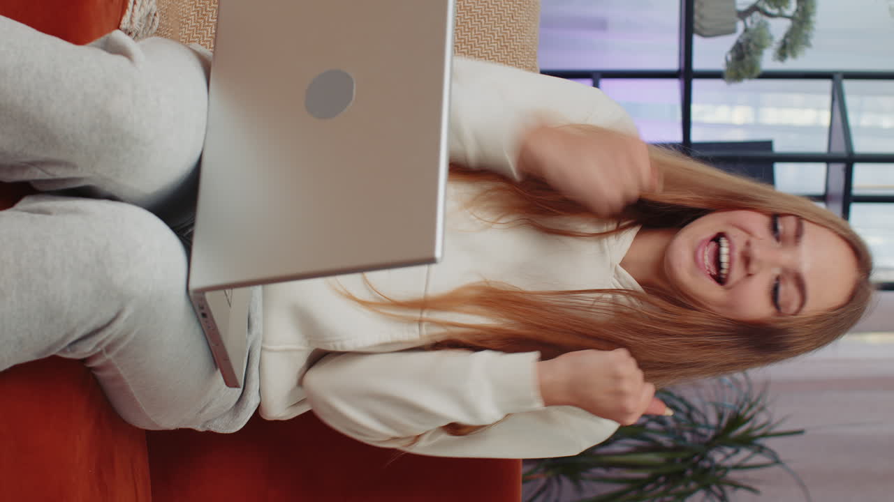 mujer joven muy feliz trabajando en una computadora portátil celebra el éxito gana dinero en la lotería consigue buenas noticias en línea