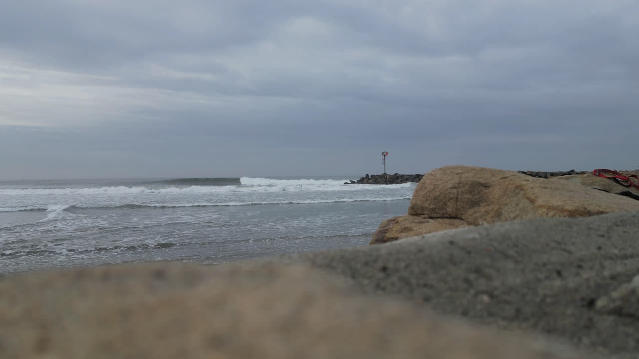 흐린 날에 바다 쪽 캘리포니아의 부두에 부서지는 파도