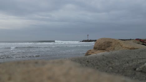 waves crashing on jetty in oceanside california on an overcast day