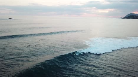 4K-Luftbild-Eines-Surfers,-Der-Im-Sonnenuntergang-Eine-Welle-Fängt,-Lombok,-Indonesien