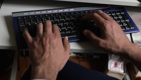 Handheld-close-up-shot-of-male-hands-typing-on-a-keyboard