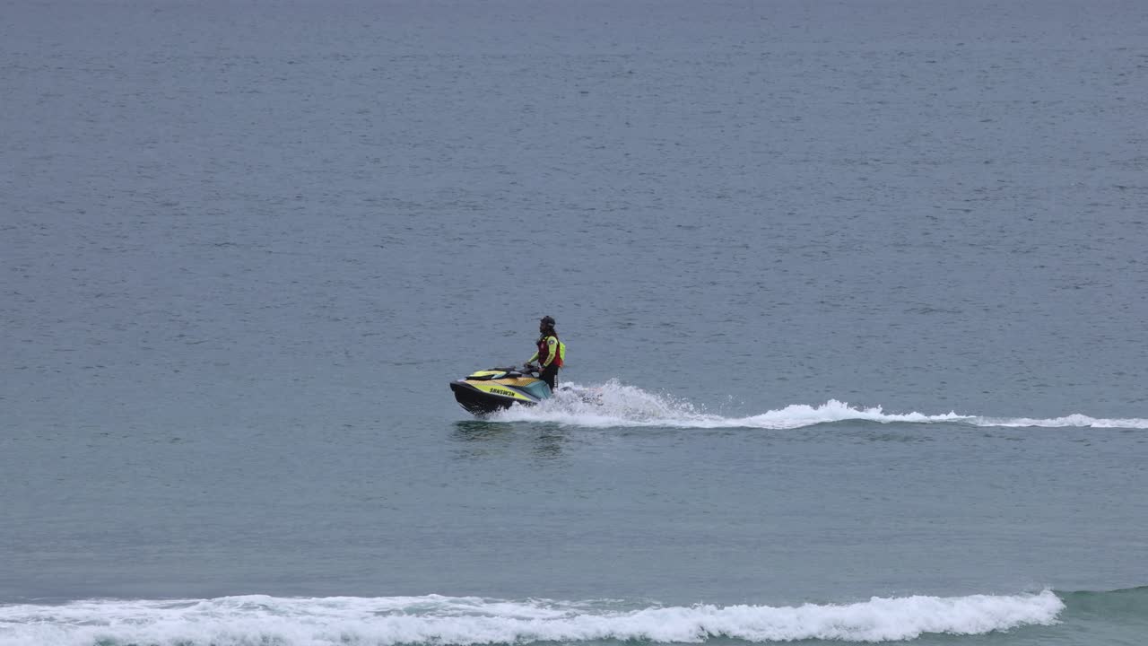 조용 한 바다 파도 를 가로질러 제트 스키 를 타고 있는 사람