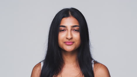 head and shoulders studio shot of woman looking at camera with serious expression in slow motion