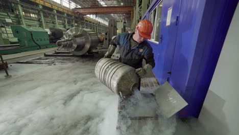 trabajador industrial que maneja un contenedor en una fábrica