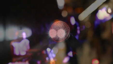 microphone grill shining under purple and yellow stage lights, animating performance audio graphics