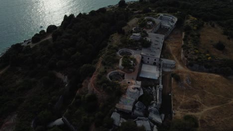 drone de vista aérea cinematográfica sobre una fortificación histórica de la fortaleza de la primera guerra mundial junto al idílico mar mediterráneo adriático junto al mar con agua azul y playas escondidas al atardecer en verano