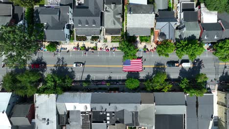 Absteigende-Luftaufnahme-In-Richtung-Der-Parade-Zum-Unabhängigkeitstag,-Die-Die-Hauptstraße-Hinaufmarschiert