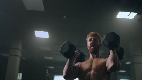 atleta masculino levantando pesadas pesas sobre su cabeza realizando ejercicios en el gimnasio. logrando el difícil objetivo de cuidar el cuerpo y la salud.