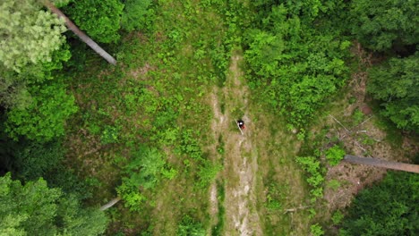 Draufsicht-Auf-Einen-Gruseligen-Sensenmann,-Der-Sich-Im-Grünen-Wald-Umdreht,-Während-Er-Eine-Sense-Hält