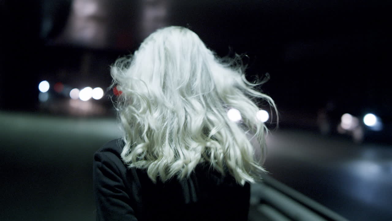 지하에 있는 도시 고속도로 자동차에서 걸어가는 행복한 밤의 여성.