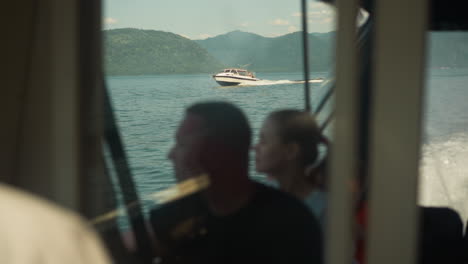 young couple relaxes on vacation on sailing boat overlooking picturesque hills against moving powerboat. enjoyment of relaxation and entertainment for tourists in summer