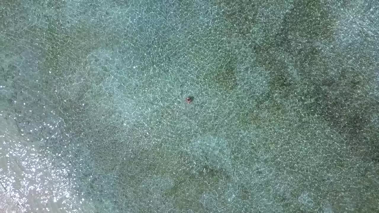 인도네시아 발리 롬복 길리 트라왕안 해변의 영상을 가리키는 맑은 물 멋진 공중 전망 비행 드론 카메라에 있는 여자