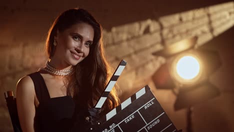 woman holding clapperboard on movie set