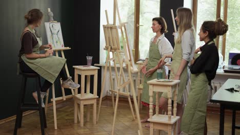 female students at art workout leading by mentor in studio