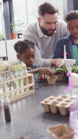 vertical video of happy diverse male teacher and schoolchildren in school classroom