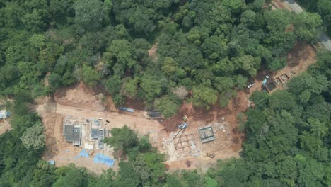 Aerial-drone-birds-eye-view,-trucking-shot-of-land-clearing-in-the-jungle-in-the-tropical-forest-by-the-coast-on-an-Island-in-Thailand