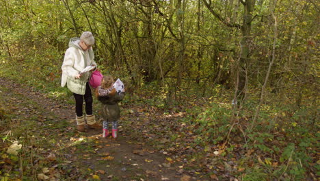 Grandmother-and-grandchild-playing-nature-game-in-forest-activities