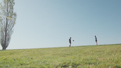wide shot of girls practicing soccer passing on green field