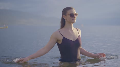 Joven-Atractiva-En-Gafas-De-Sol-Chapoteando-En-El-Agua