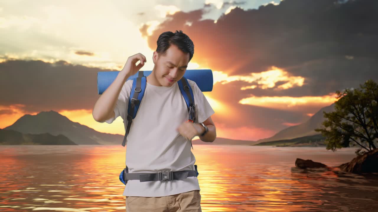 un excursionista asiático con una mochila de montañismo disfruta bailando en un lago