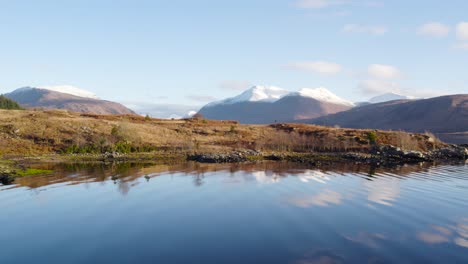 Imágenes-Aéreas-De-Drones-Volando-Cerca-Del-Agua-De-Loch-Etive-Y-Elevándose-Lentamente-A-Una-Vista-épica-Real-De-Glen-Etive-En-Las-Tierras-Altas-De-Escocia-Con-Montañas-Nevadas-Y-Hermosas-Aguas-Reflectantes