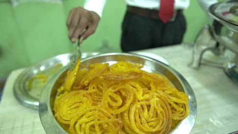 Filmaufnahme-In-Zeitlupe-Von-Köstlichen-Jalebis,-Die-In-Einem-Buffet-Aufbewahrt-Werden