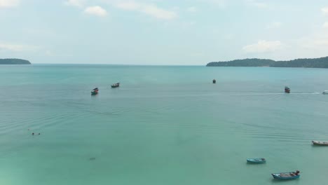 panoramic view of encircling bay populated by fishing boats moored above the turquoise sea in saracen bay in koh rong sanloem, cambodia - aerial panoramic view