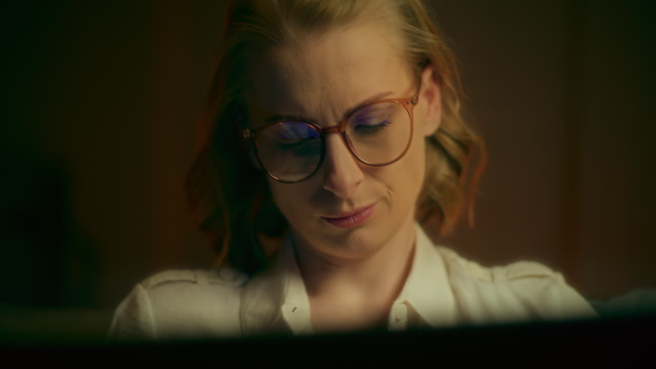 mujer concentrada trabajando hasta tarde en la computadora portátil