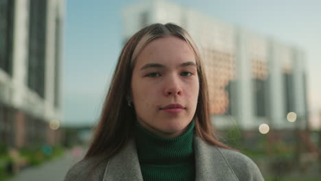close up of student holding book to cover face then gently removing it with calm thoughtful expression outdoors, showing lifestyle, study, and reflective mood in modern city residential background